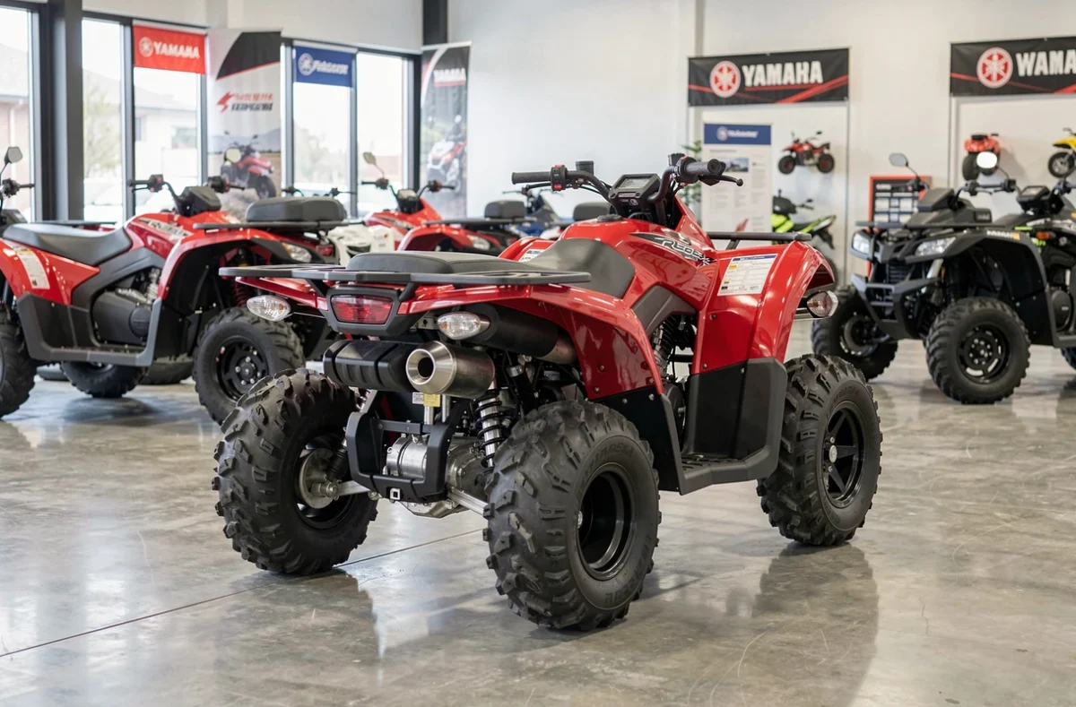 Yamaha Raptor 700 exposé dans une concession ATV, vue trois quarts arrière sur sol en béton poli avec suspension mono-amortisseur visible